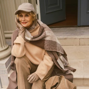 A person seated on stairs wearing layered clothing and accessories A person seated on stairs wearing layered clothing and accessories