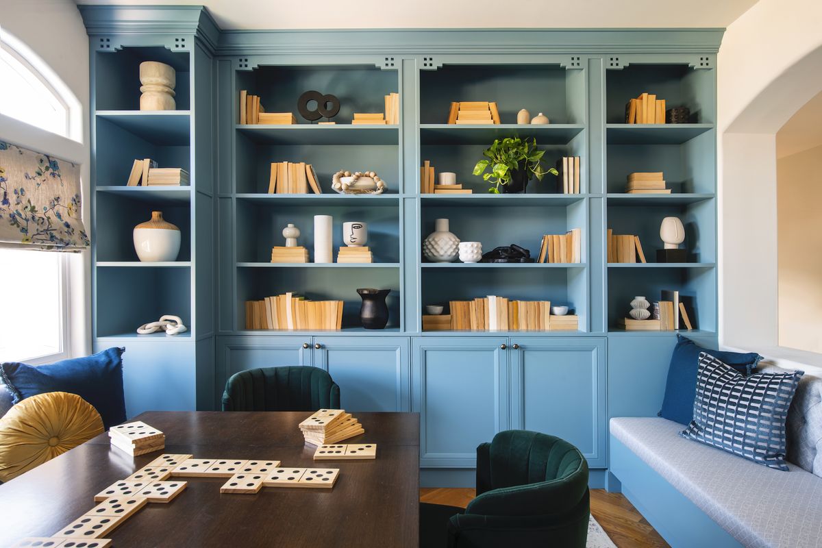 game room with built in shelving painted in light blue