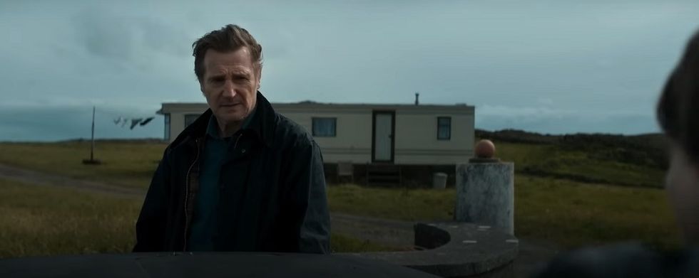 Im Film „Das Land der Heiligen und Sünder“ von Liam Neeson steht seine Figur vor einem Wohnwagen und sieht besorgt aus