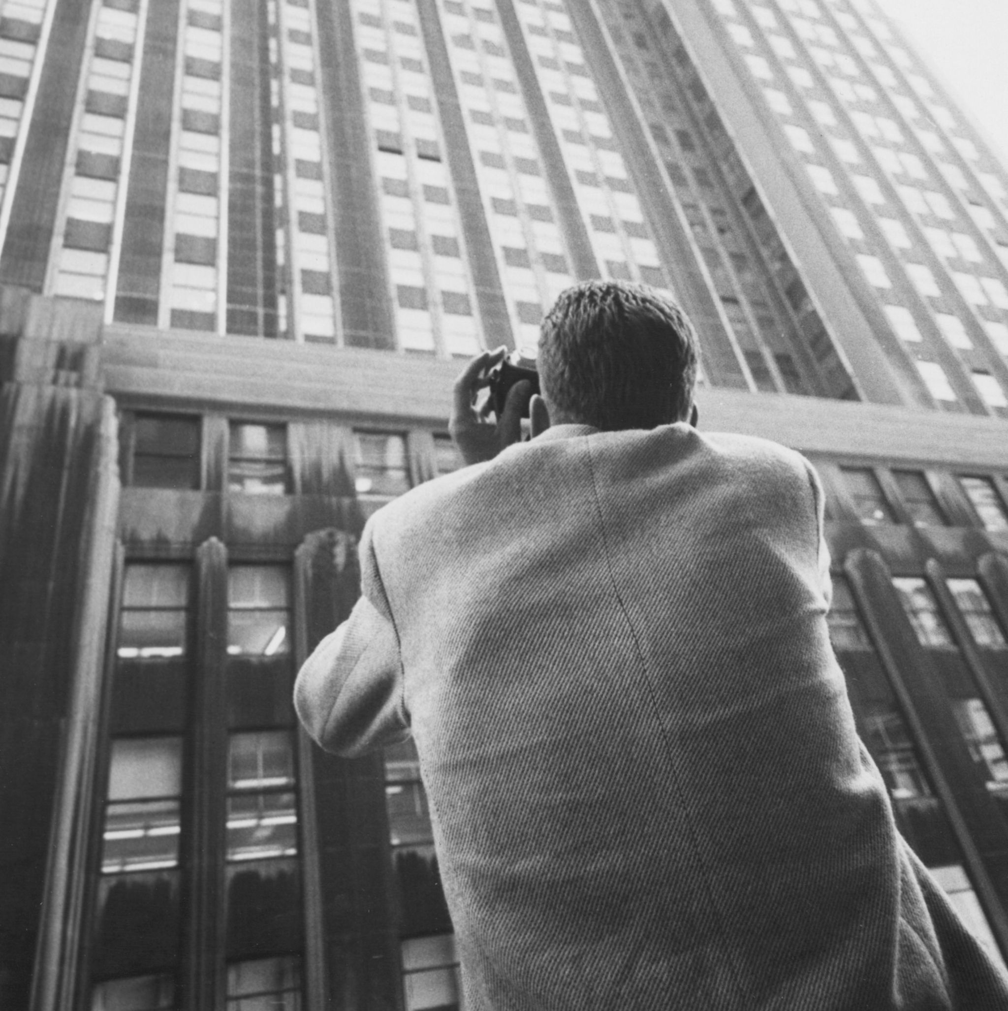 a man taking a picture of a tall building