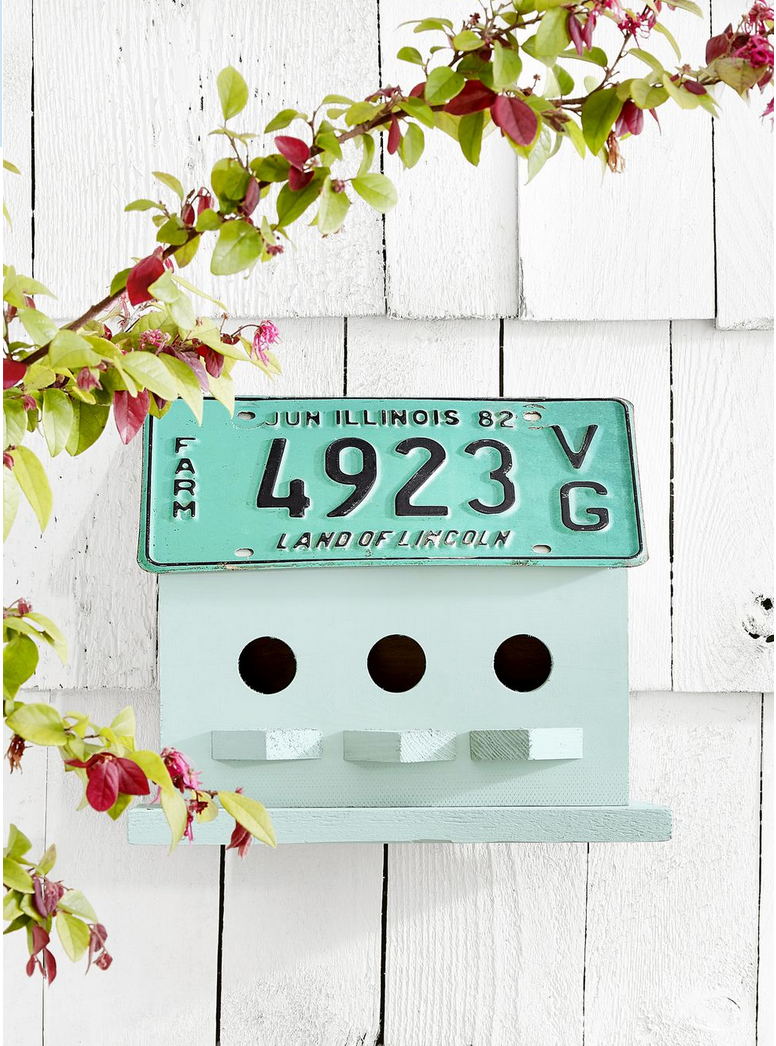 A birdhouse with a vintage license plate as the roof