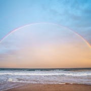 Scenic view of rainbow over sea against sky scenic view of rainbow over sea against sky