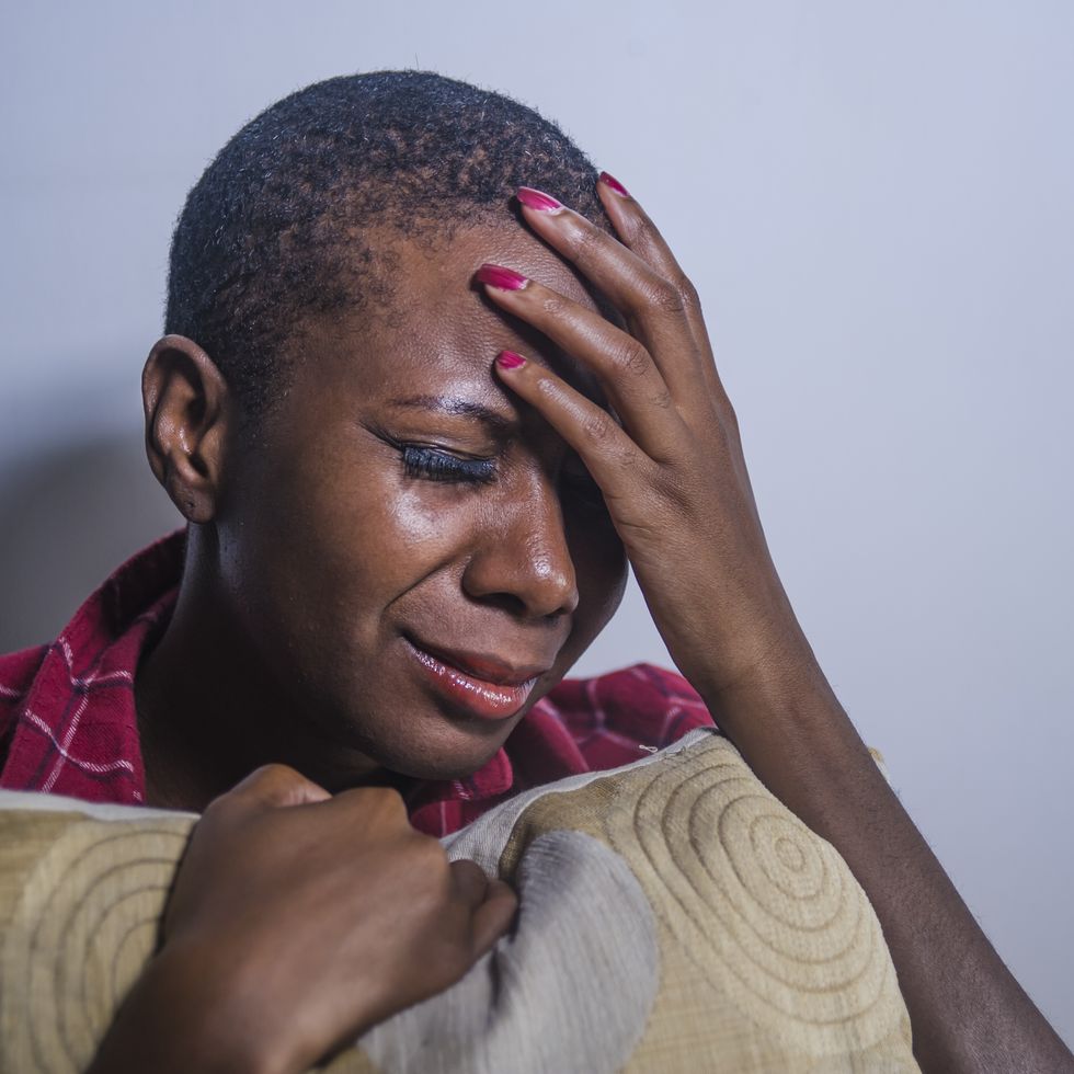 how to forgive yourself lifestyle indoors shady portrait of young sad and depressed black afro american woman sitting at home floor feeling desperate and worried suffering pain and depression in dramatic light
