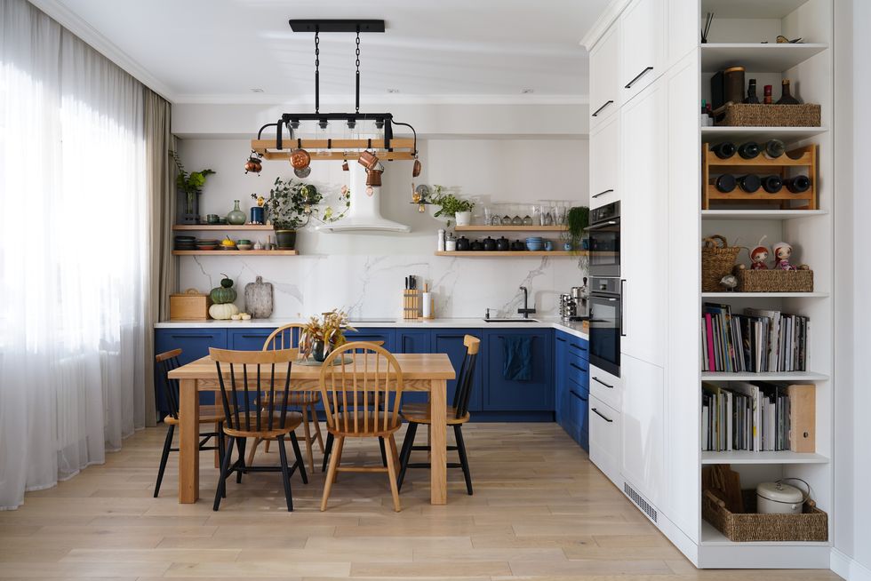 light cozy kitchen with blue and white facades and open shelves with autumn decor