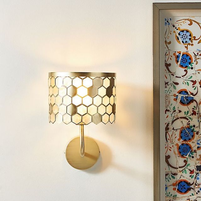 honeycomb sconce attached to wall next to painting