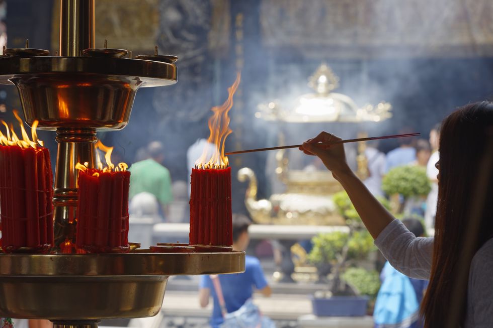 lighting a joss stick in longshan templetaipei