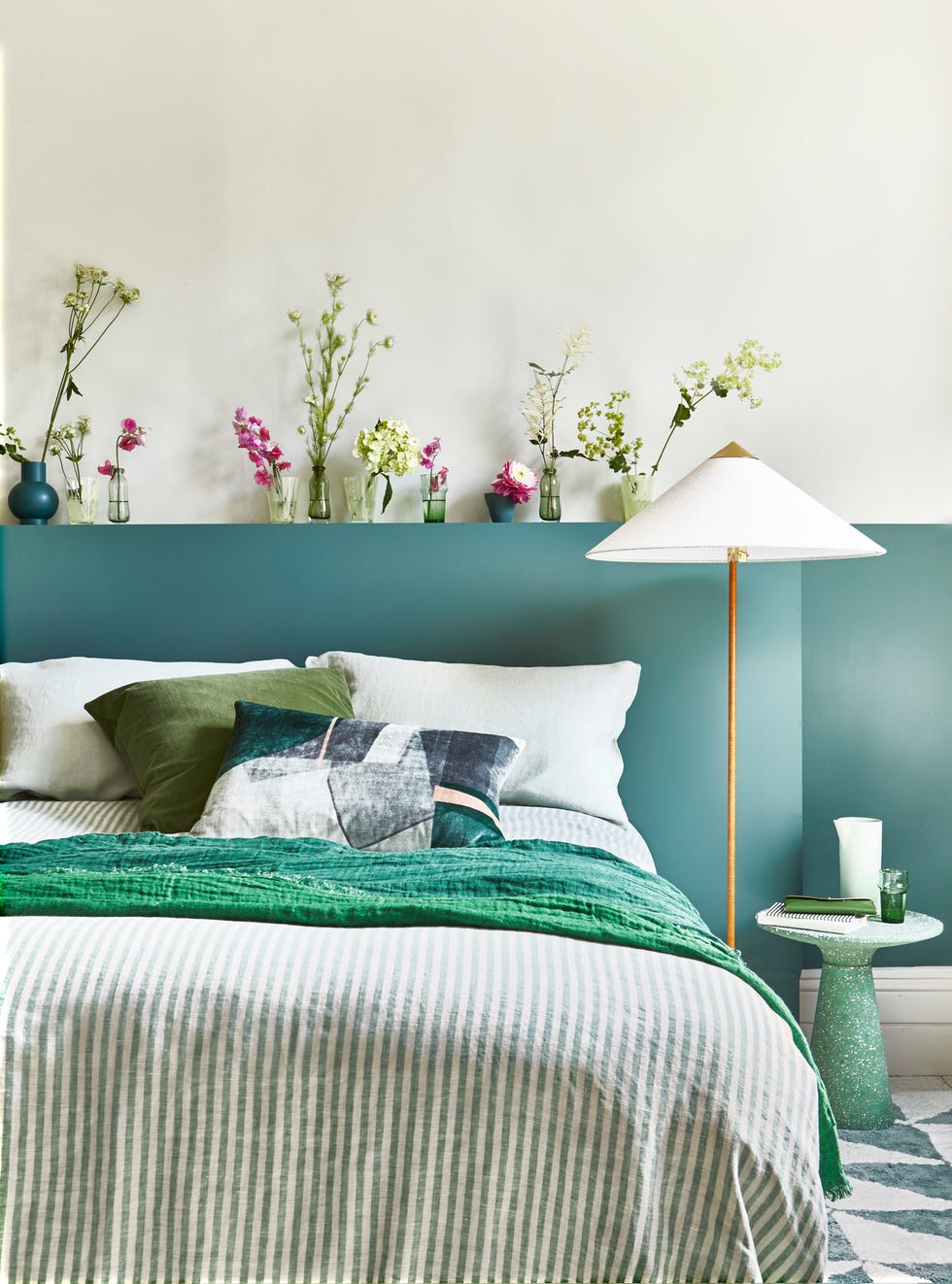 bedroom with green sheets and flowers