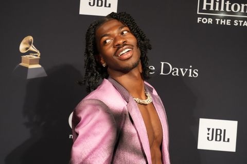 lil nas x posing in front of an award show backdrop