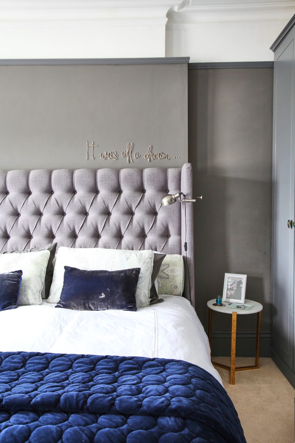 button back bed with navy throw