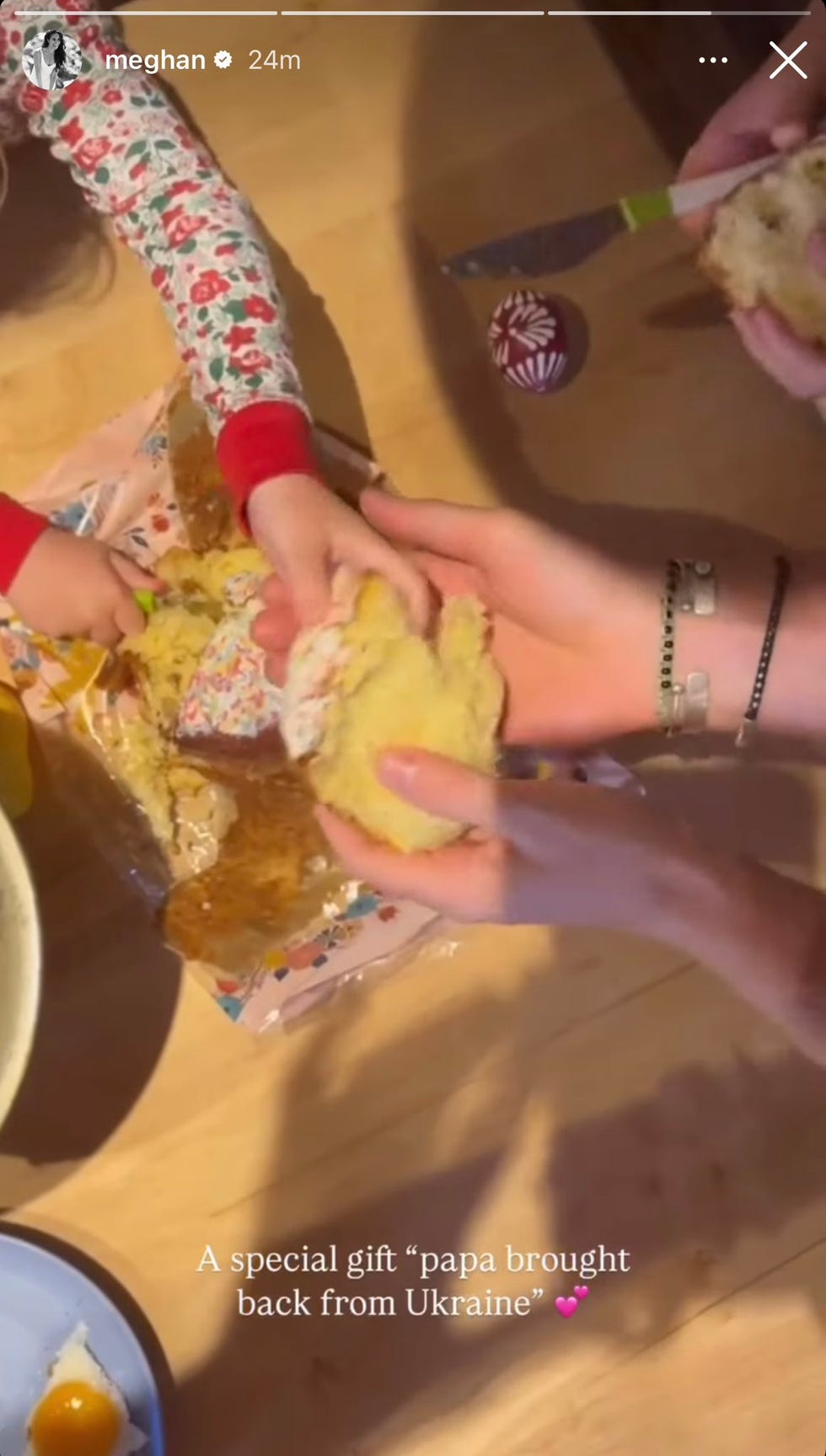 hands interacting with a baked good and various objects on a table