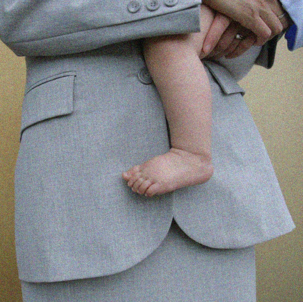 a woman in a business suit holding a baby