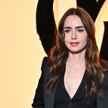 lily collins wears a waist coat and suit with long shiny dark brown hair and red lipstick