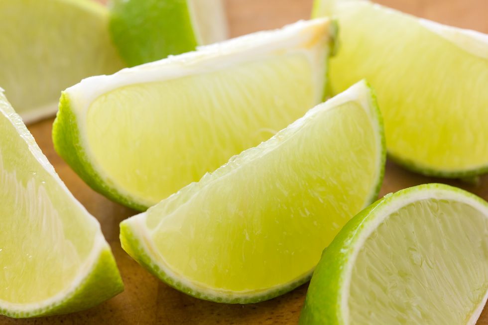 lime wedges arranged on a wooden board. selective focus.