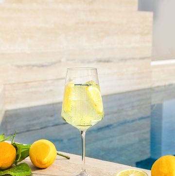 limoncello spritz aperitif drink next to swimming pool with fresh amalfi lemons