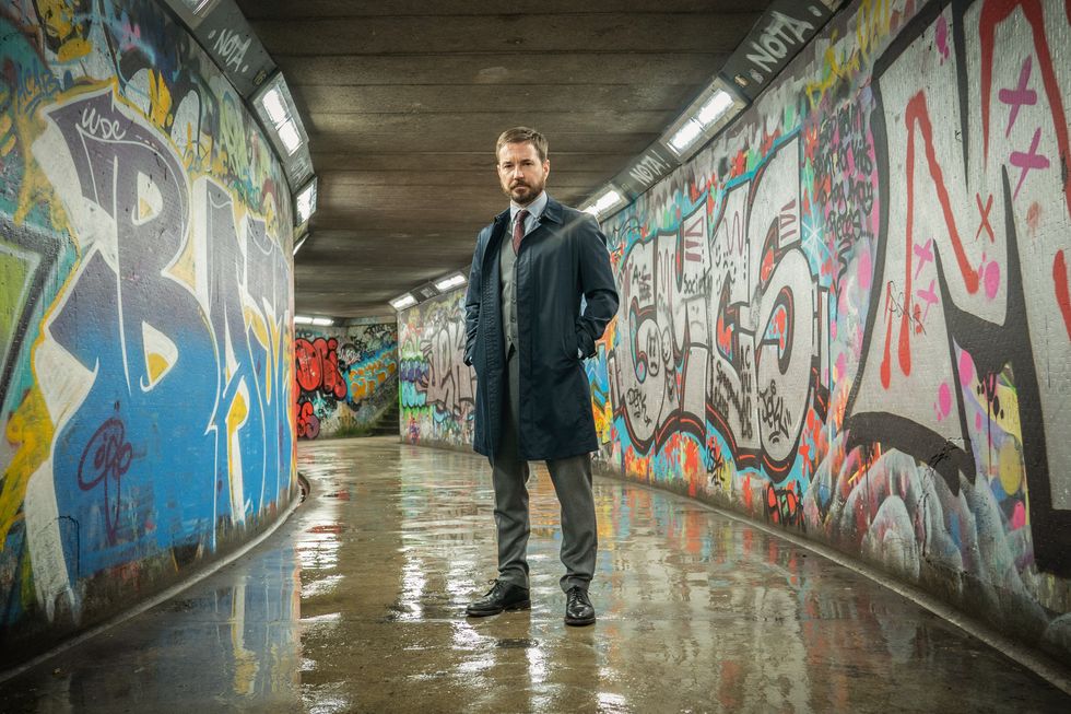 line of duty series 6 episode 2  martin compston as steve arnott, standing in an underpass with graffiti covered walls
