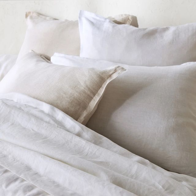 a white bed with white sheets