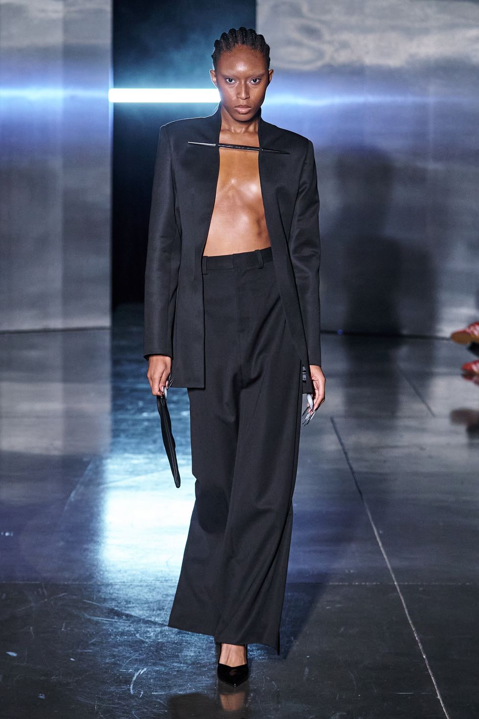 a model walks the grace ling runway in a black blazer and black column skirt