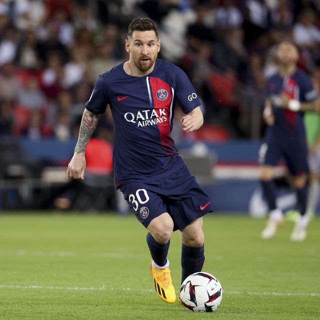 lionel messi looking upfield as he handles a soccer ball