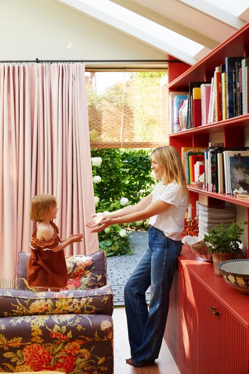 a woman and a child in a room with a window