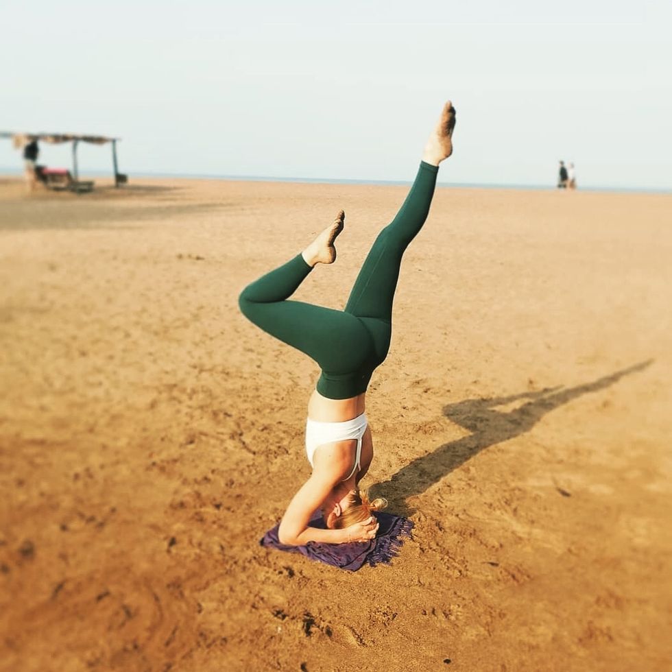 woman doing yoga pose on beach