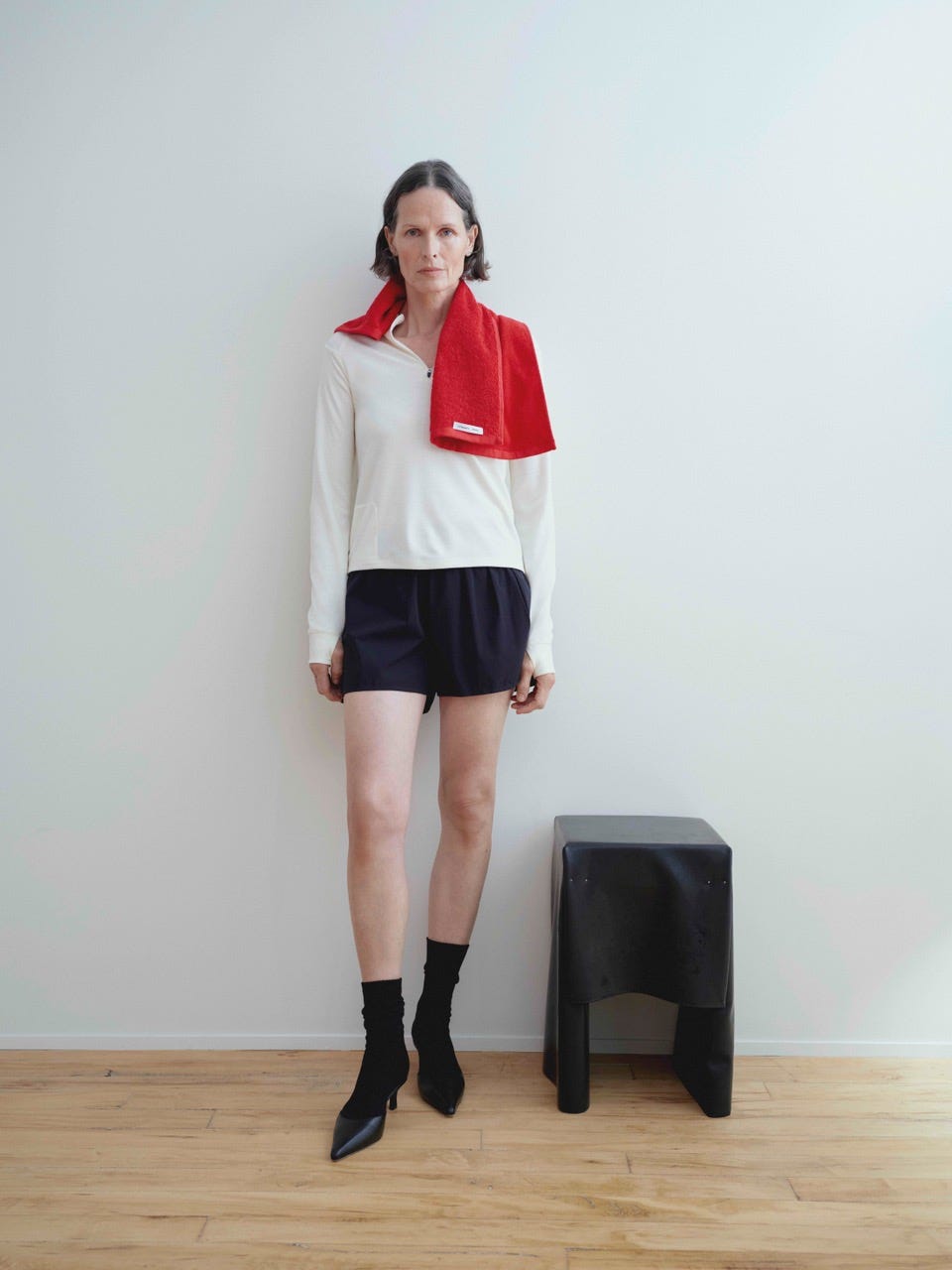 person wearing a sporty outfit with a towel draped over the shoulder