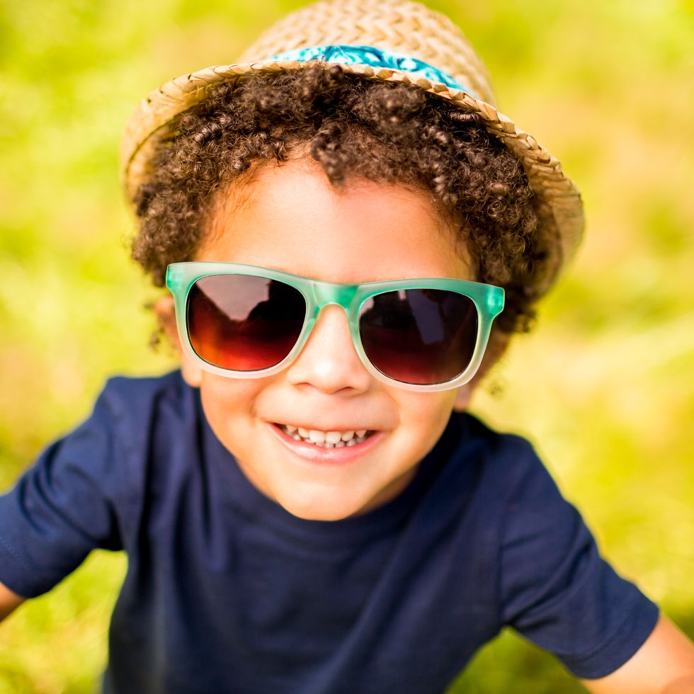 little boy smiling at camera in park