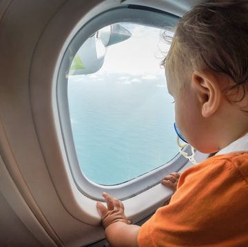little boy watching through window airplane
