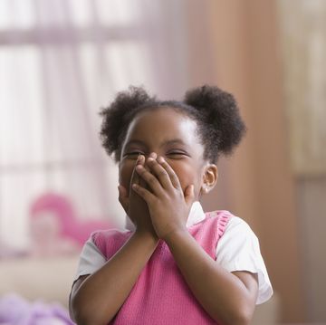 african american girl laughing, hands covering mouth