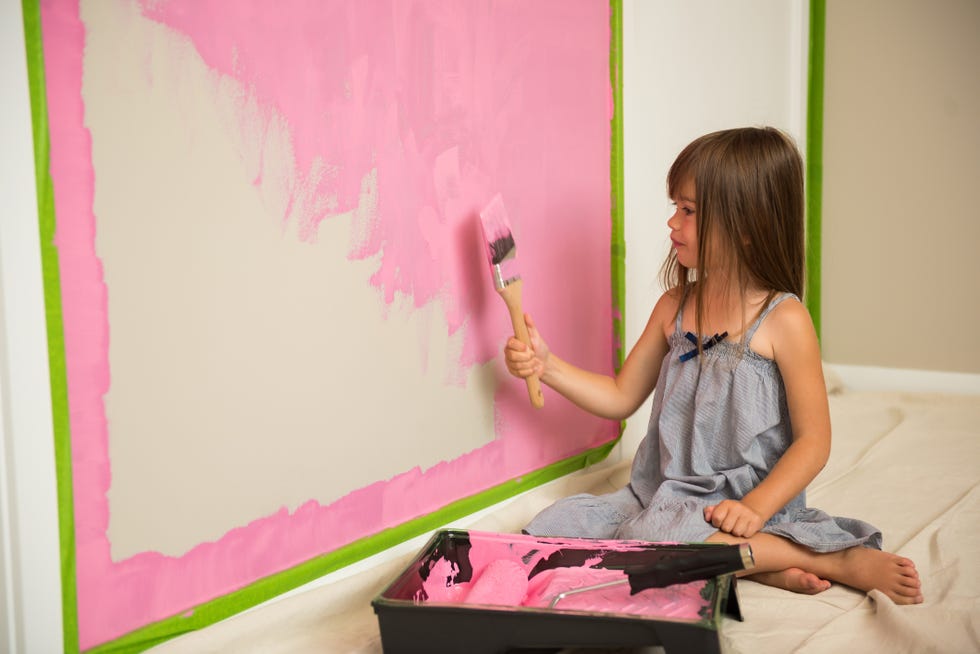 little girl painting her room pink