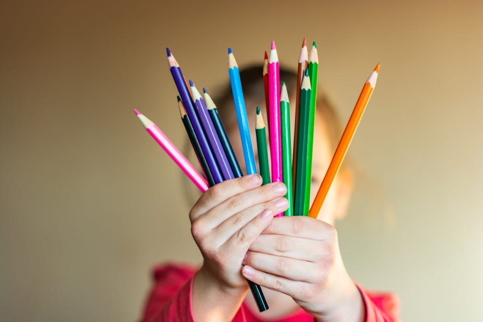 little hand holding the colored pencils