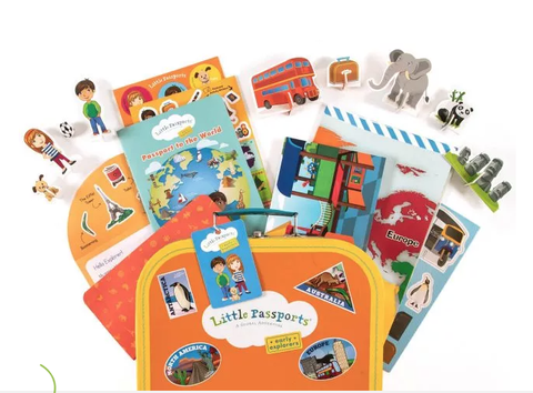 little passports subscription kit contents that includes themed global accessories and toys like a double decker bus elephant and others