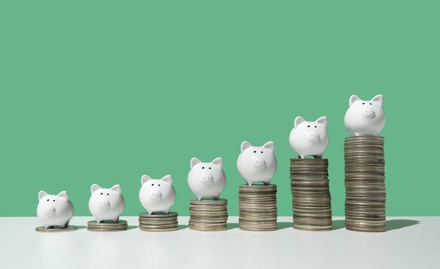 Little piggy banks on ascending stacks of coins