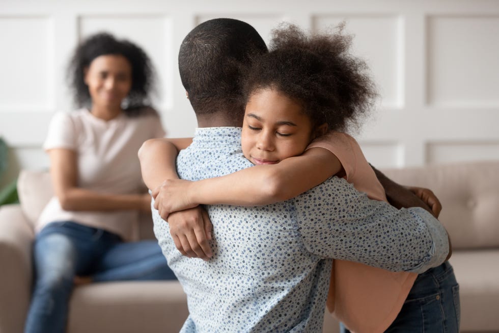 little school girl embracing mixed race father