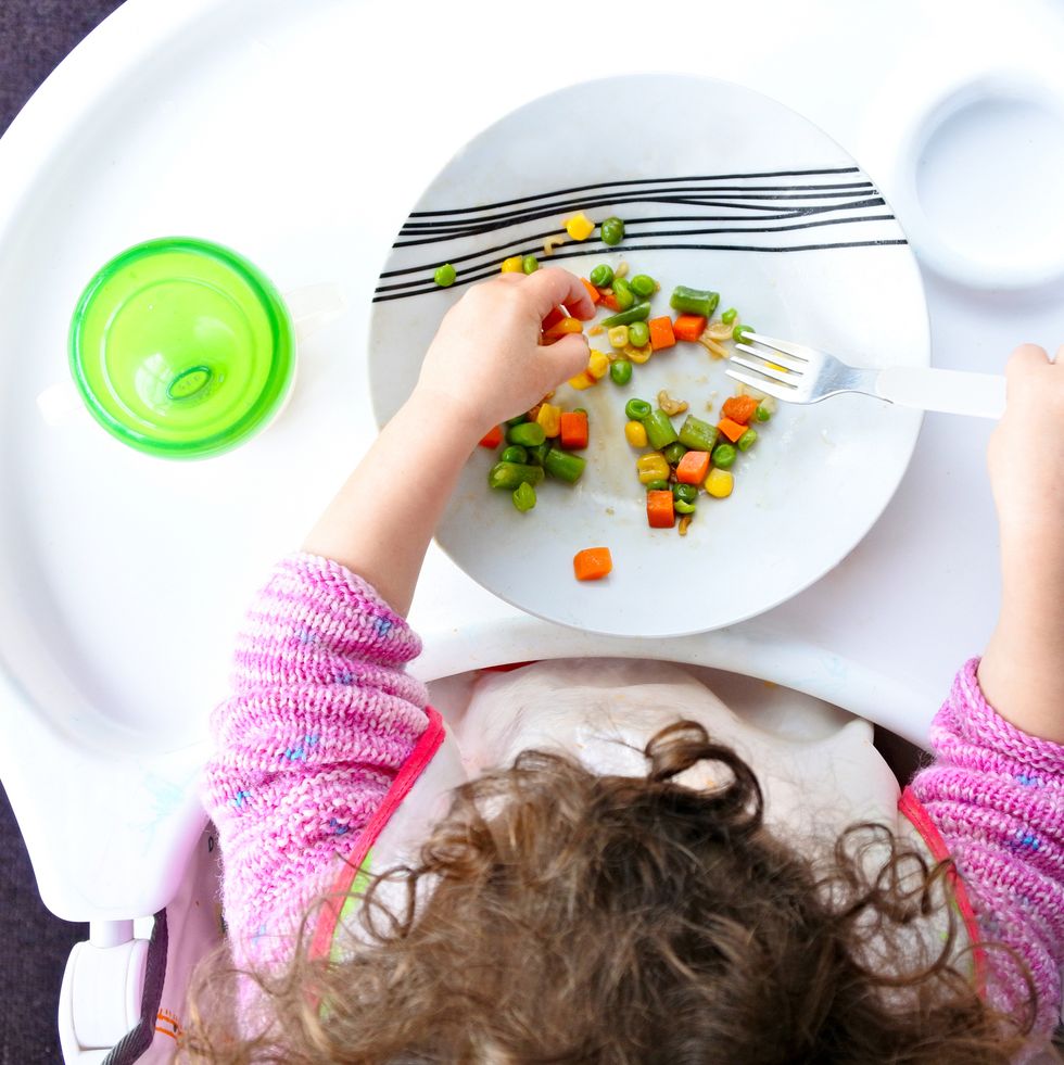 little toddler child eats vegetables