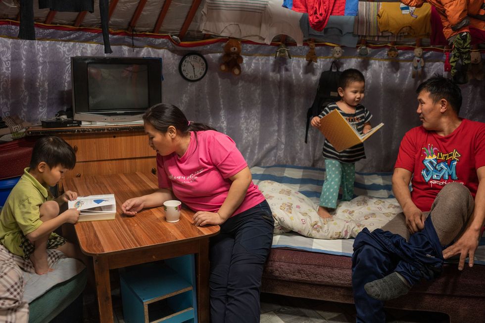 Dejid Bayarbaatar enTodgerel Lkhamjav bereiden hun twee jongste kinderen voor op bedtijd in hun huis in Nalaikh district