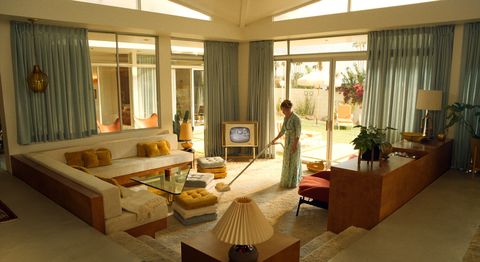 florence vacuuming in the living room on set