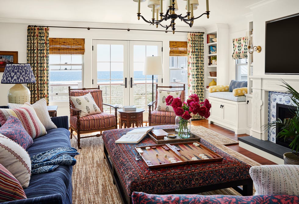 living room with patterned ottoman, dark blue sofas, decorative pillows