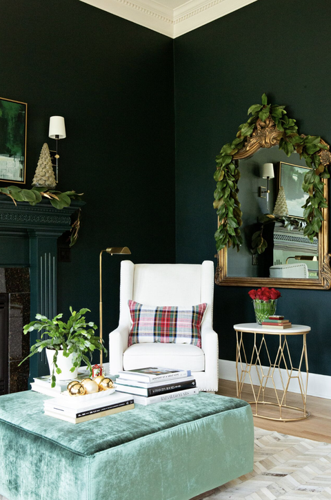 living room ideas, living room with forest green walls, a white chair and mirror with greenery