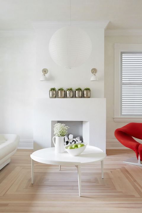 white living room with paper pendant light and red chaire