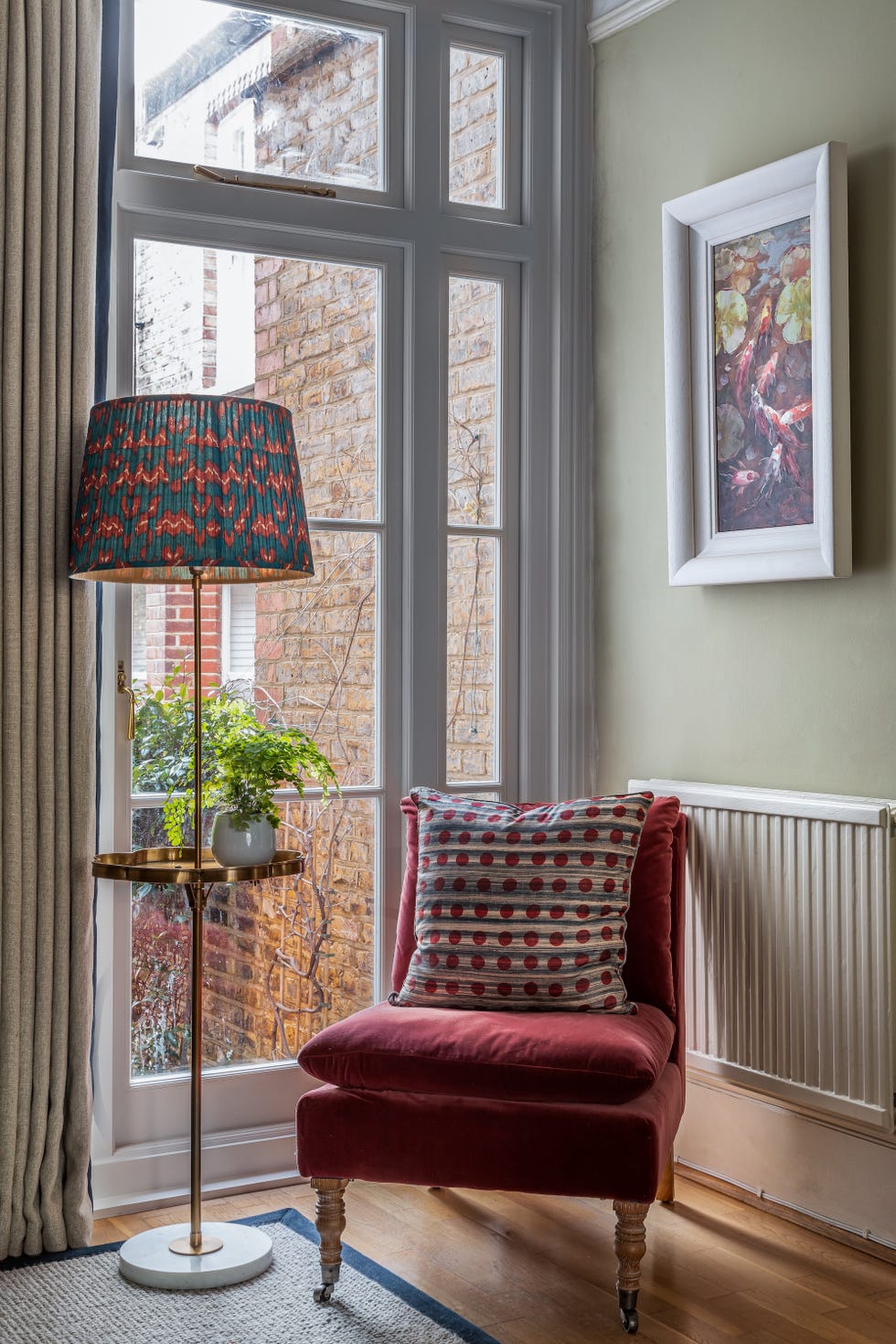 a living room with long curtains, armchair and window