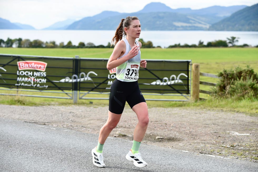 woman running beside a loch