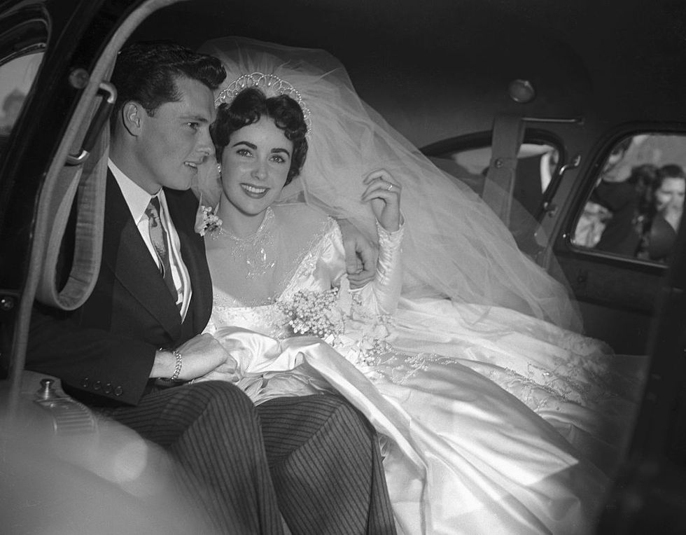 actress elizabeth taylor and her groom, conrad nickie hilton, jr in the limousine that will take them to their wedding reception at the bel air country club, following their marriage at the church of the good shepherd in beverly hills