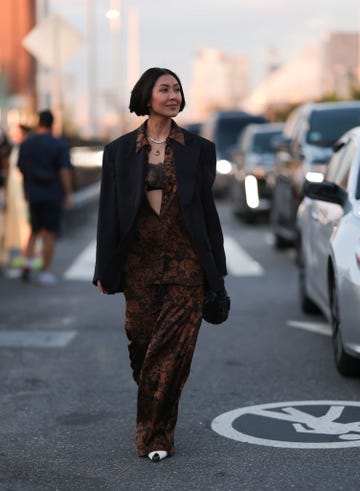 a woman wearing a black lace bra with a brown and black printed shirt and black blazer in the street in new york city in a roundup of best bra brands 2024