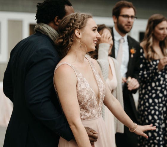 lauren and her fiancé dancing at her sister's wedding in an article about men and wedding planning
