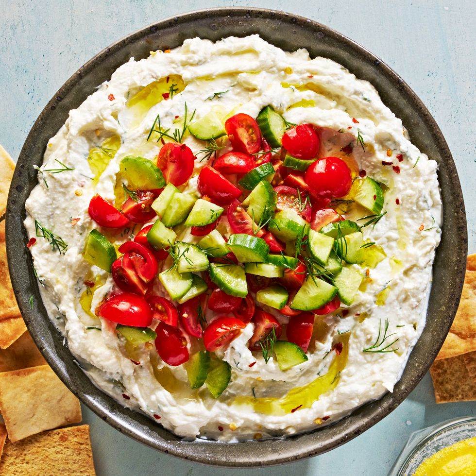 feta dip topped with tomatoes and cucumber