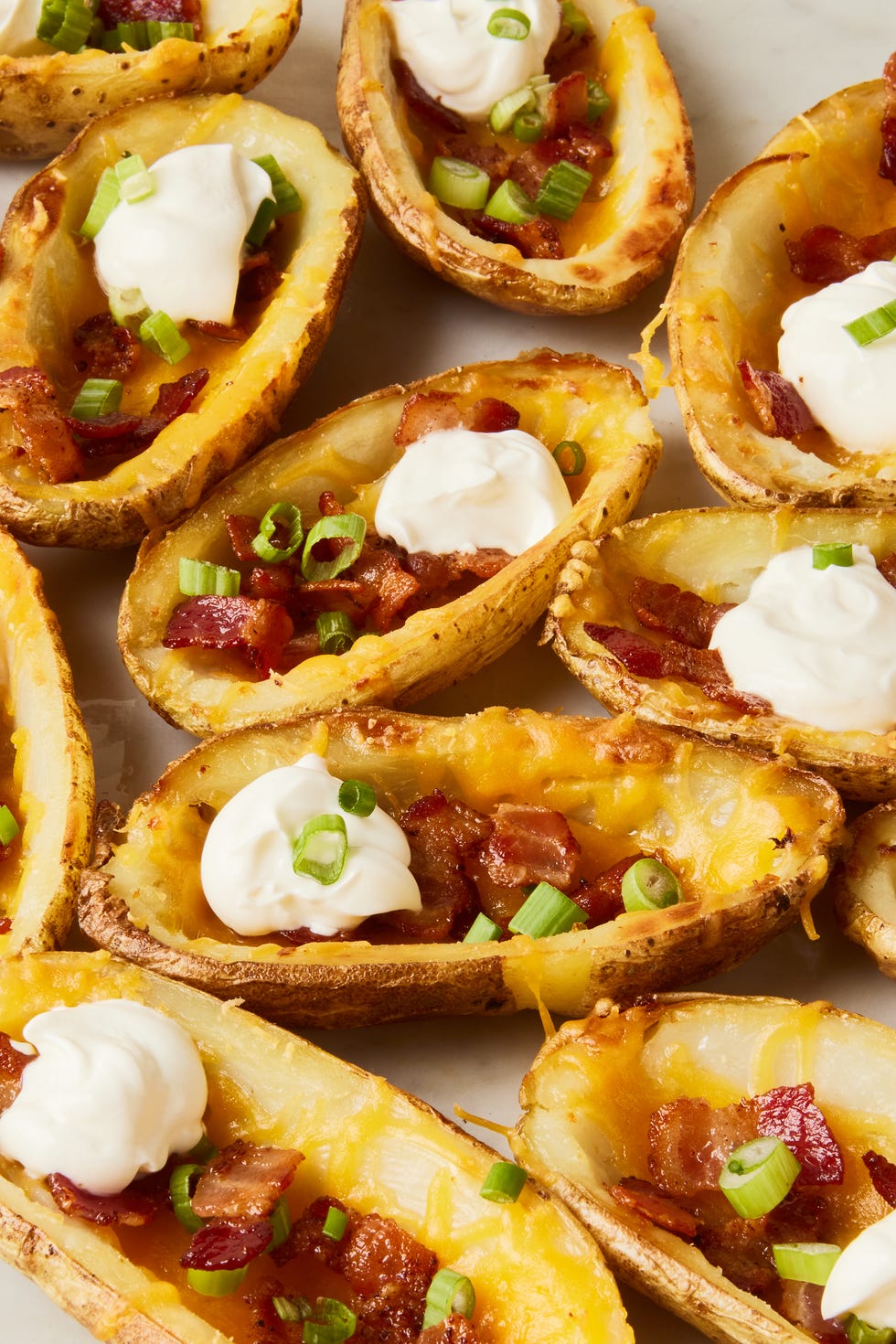 potato skins topped with bacon, chives, and sour cream dollops