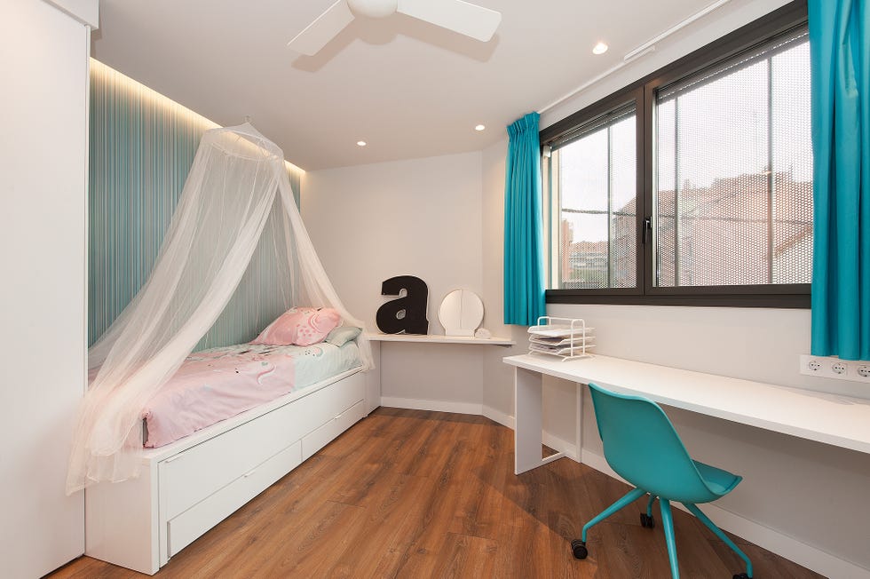 habitación infantil con dosel y escritorio en colores blanco y azul