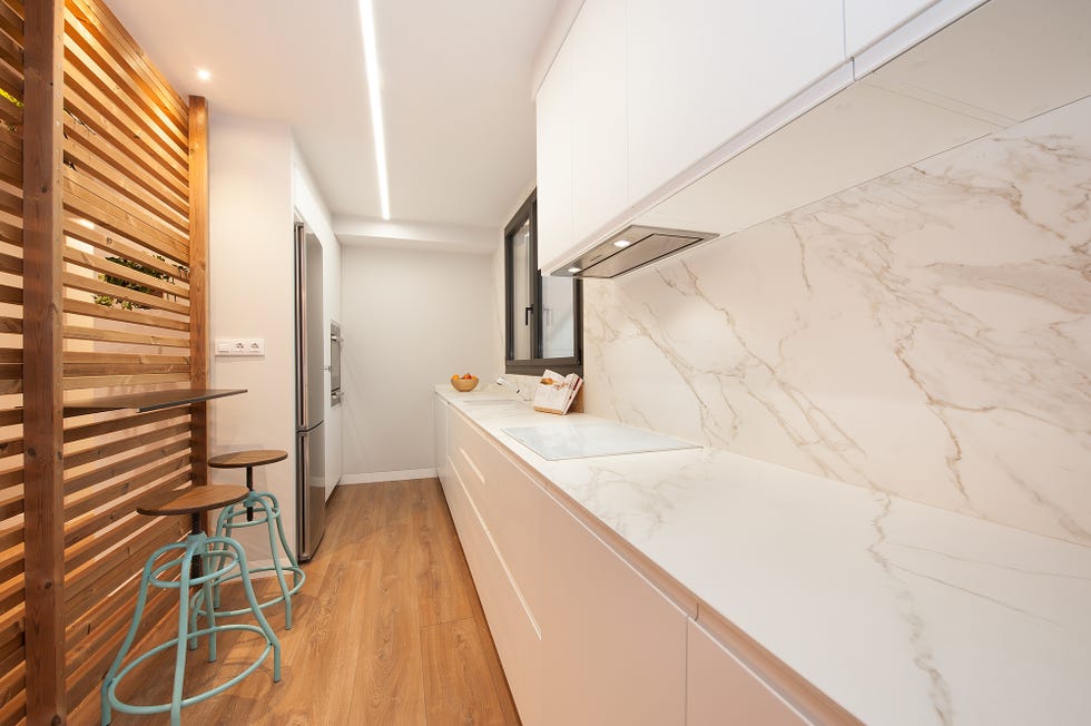 cocina abierta diseñada en blanco con encimera y frente efecto mármol