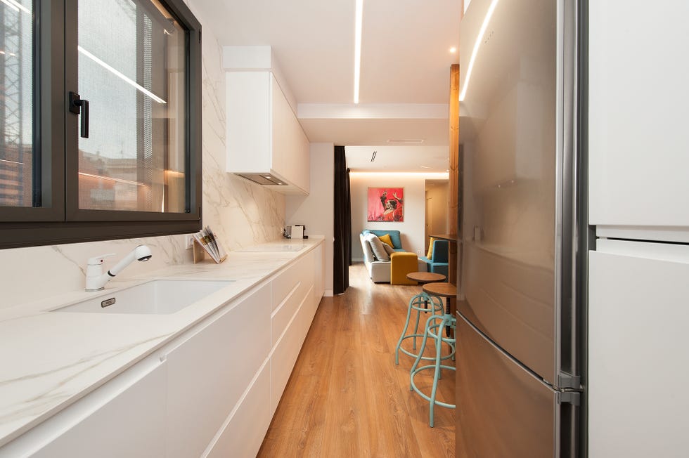 cocina abierta diseñada en blanco con encimera y frente efecto mármol