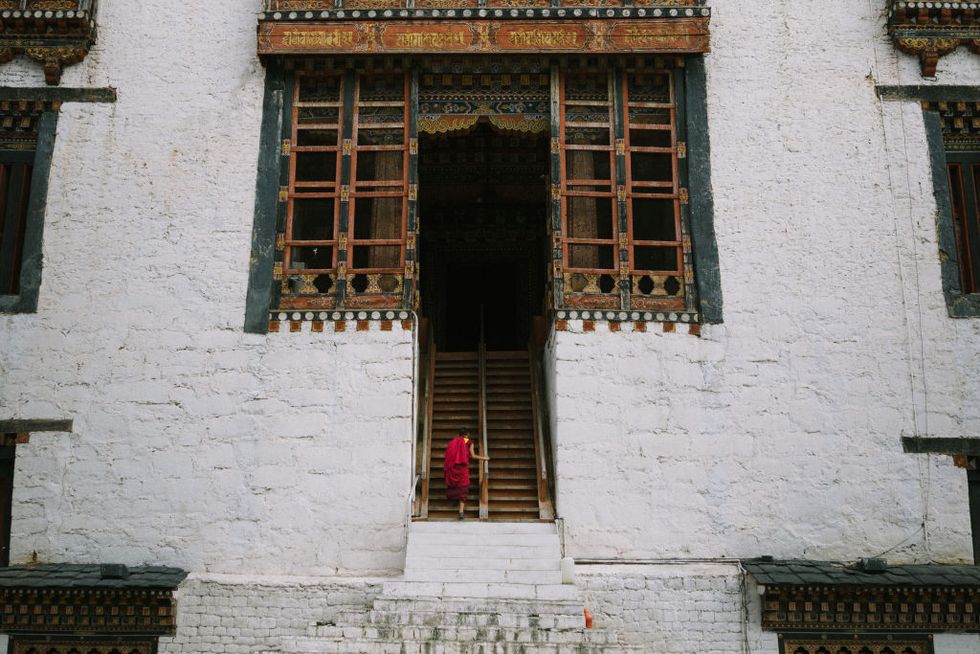 A local monk ascending up the stairs that leads to a...